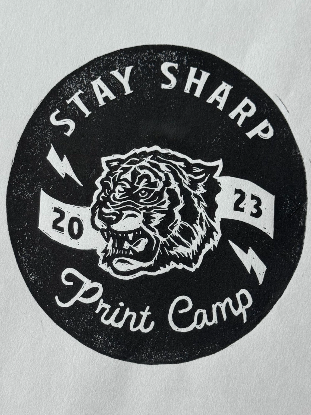 A black and white circular relief print featuring a fi