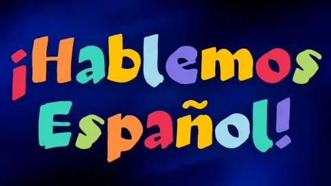 A graphic with the phrase '¡Hablemos Español!' (Let's speak Spanish!) displayed in a playful, hand-drawn style. Each letter is a different vibrant color (red, orange, yellow, green, teal, and purple) against a dark blue background.