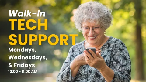 A promotional graphic with a bright, out-of-focus outdoor background of green leaves and sunlight. On the left side, "Walk-In TECH SUPPORT" is written in bold yellow letters. Below that, in smaller text, the days and times are listed: "Mondays, Wednesdays, & Fridays 10:00 - 11:00 AM." A smiling elderly woman with grey curly hair and glasses is shown on the right, looking down at her cell phone and holding it with both hands.